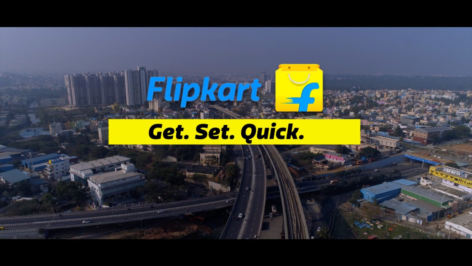 Flipkart delivery person handing over groceries in a city for quick-commerce service.