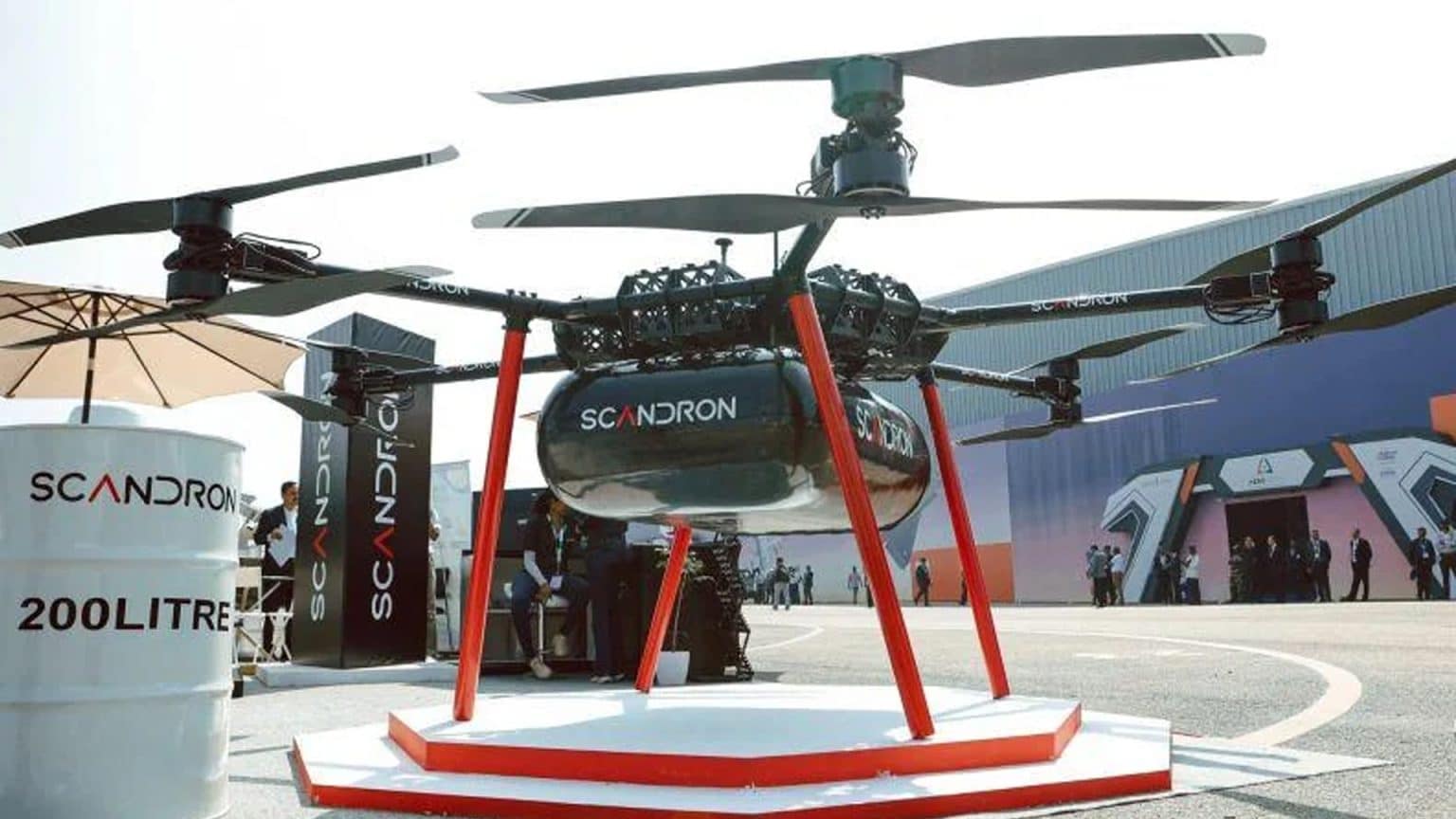 SCM Spectrum - Scandron CargoMax 20KHC drone carrying a heavy payload, showcasing its autonomous flight capabilities over rugged terrain.