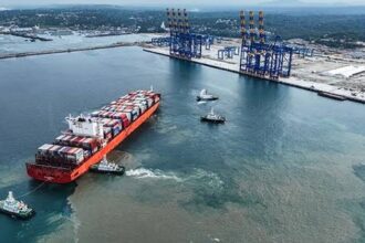 Aerial view of Vizhinjam International Seaport with large cargo ships docked and advanced port infrastructure in operation.