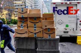SCM SPECTRUM - FedEx delivery truck parked outside a residential home with Amazon large package